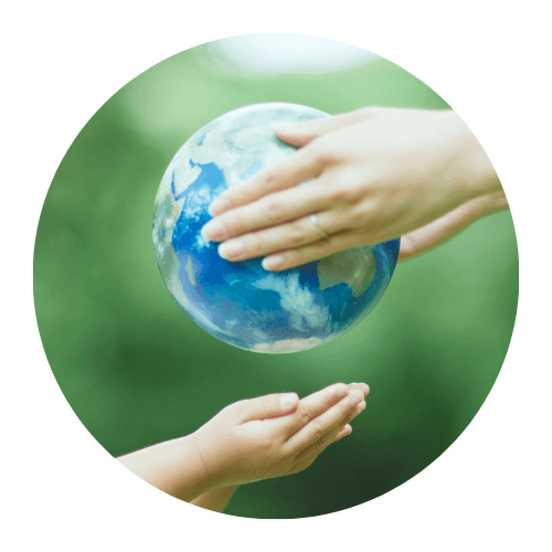 Adult hands passing a globe to a child's cupped hands against a green background, symbolizing global stewardship.